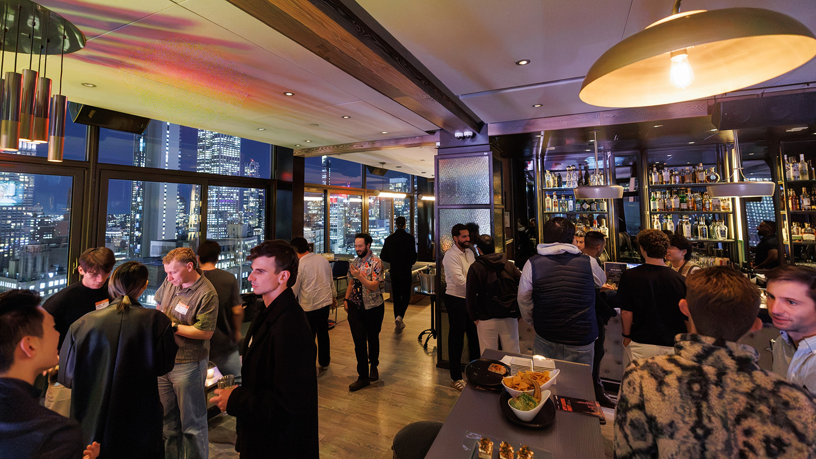 the App Leaders Party crowd at the Skylark bar with Midtown lit up through the windows
