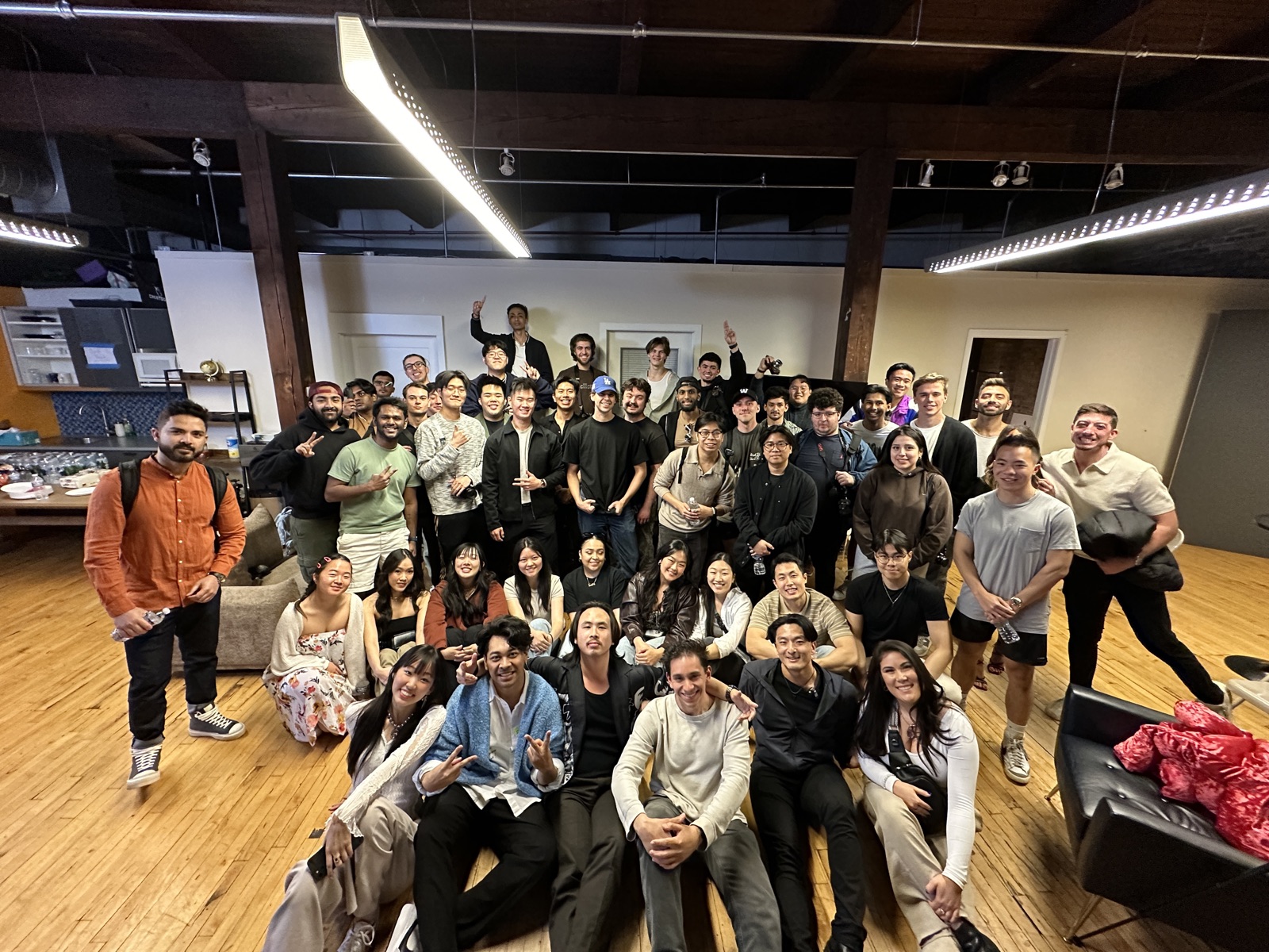 60 creators posing in a Chicago loft, front row on the floor, at Chicago2Create event 2