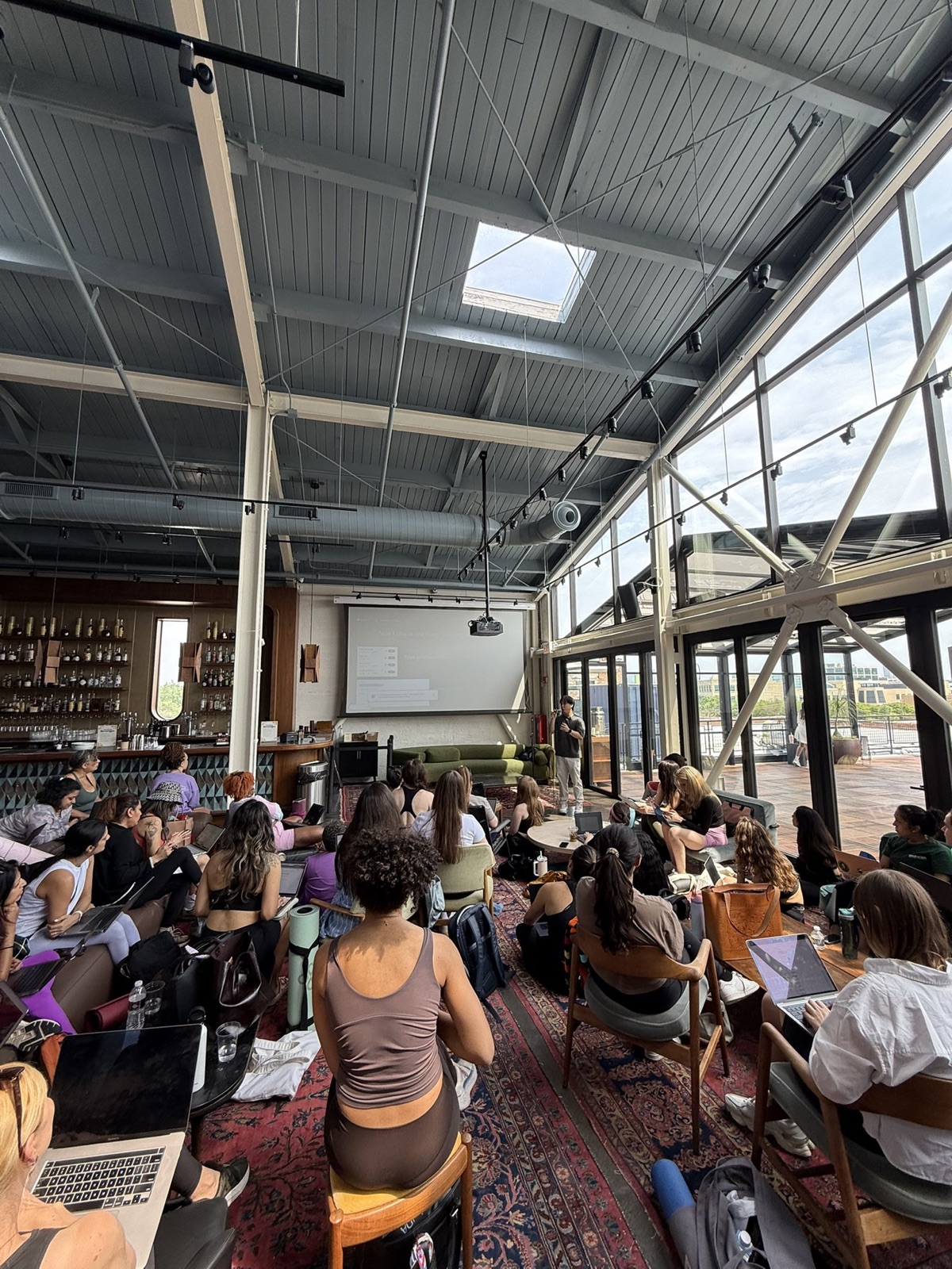 the workshop at HGVC x Adapty: a rooftop room of builders on laptops at the Salt Shed