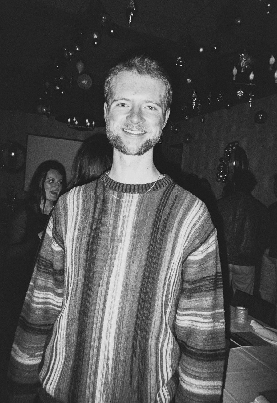 guest in a striped knit sweater smiling for a portrait