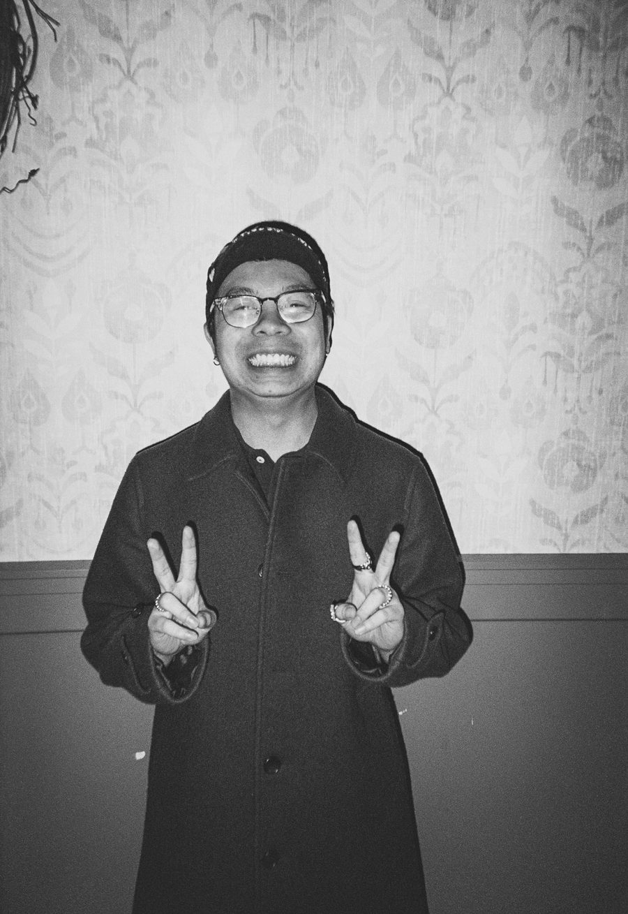 guest in a cap and glasses throwing double peace signs