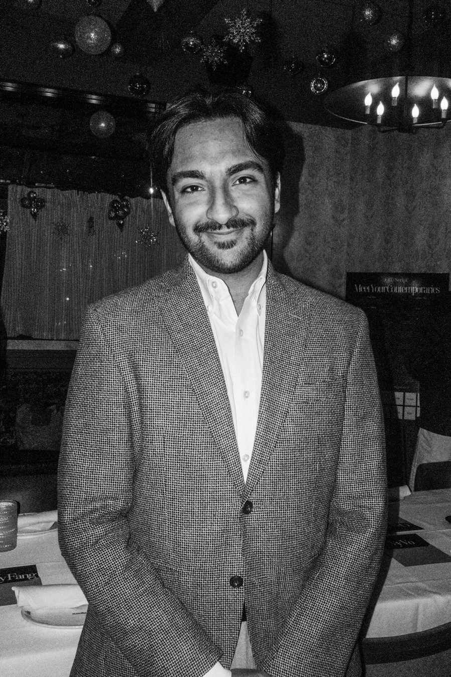 guest in a grey tweed blazer with hands folded